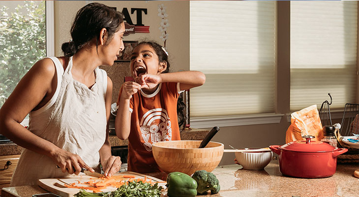 Mãe e filho brincando na cozinha.